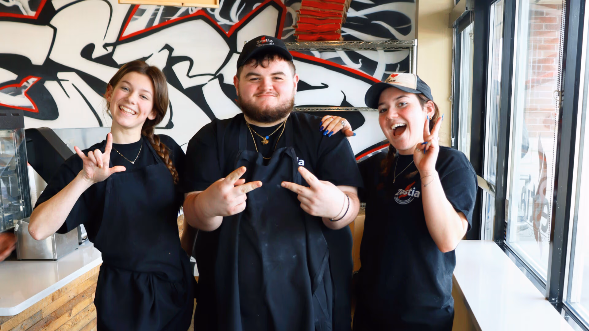 Three Zestia team members behind the counter